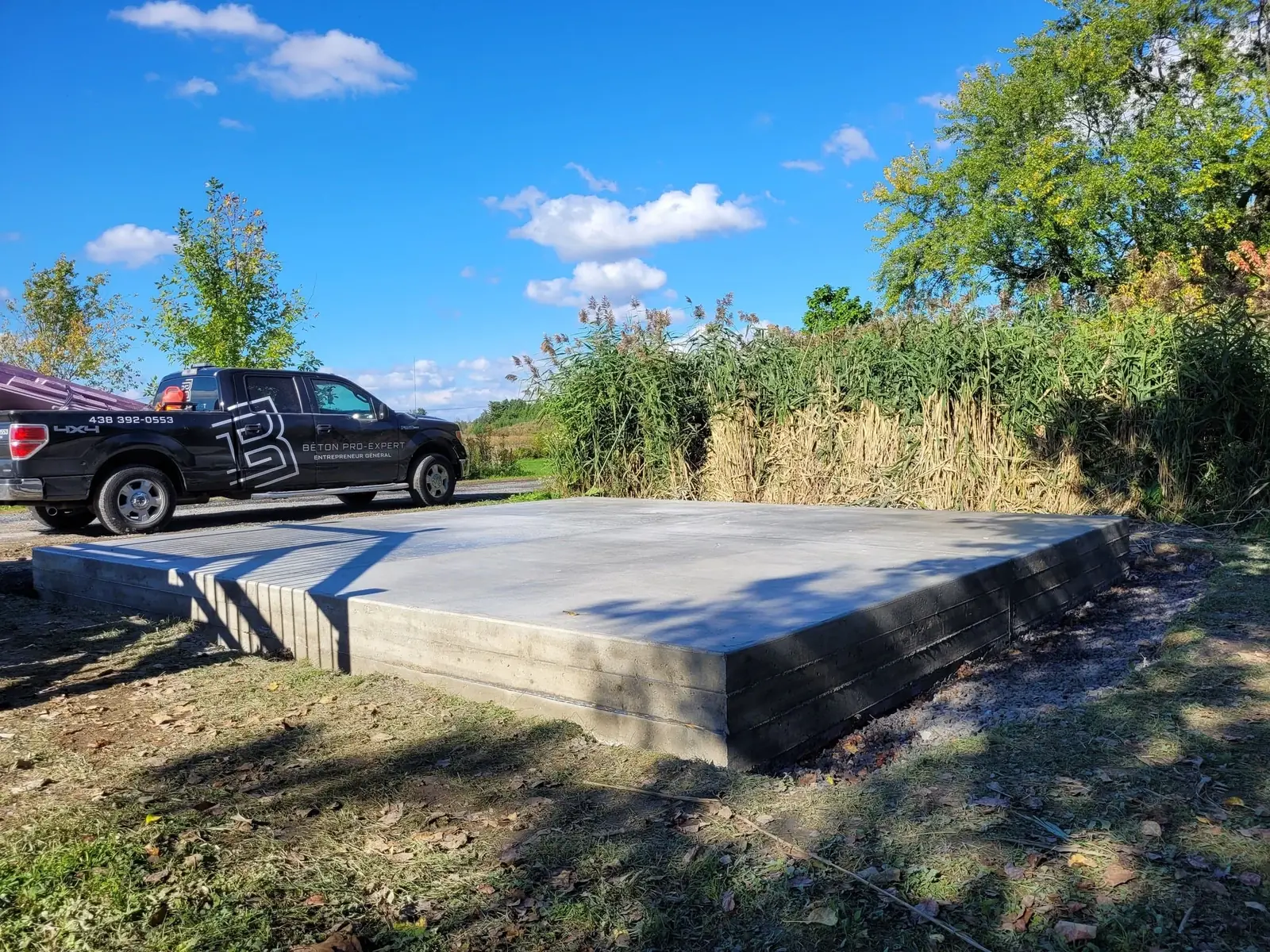 Dalle de béton réalisée par Béton Pro-Expert, camion de l’entreprise en arrière-plan